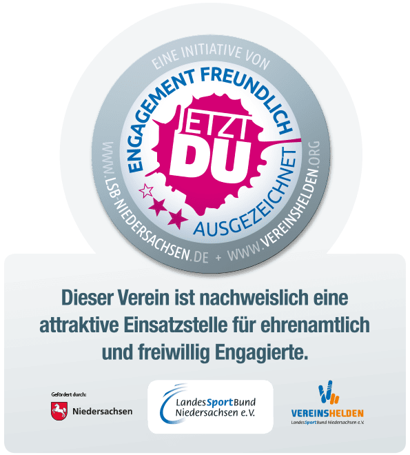 Rundes Logo mit der Aufschrift „Jetzt du“ und den Worten „Engagement freundlich ausgezeichnet“ in pink auf blauem Hintergrund.